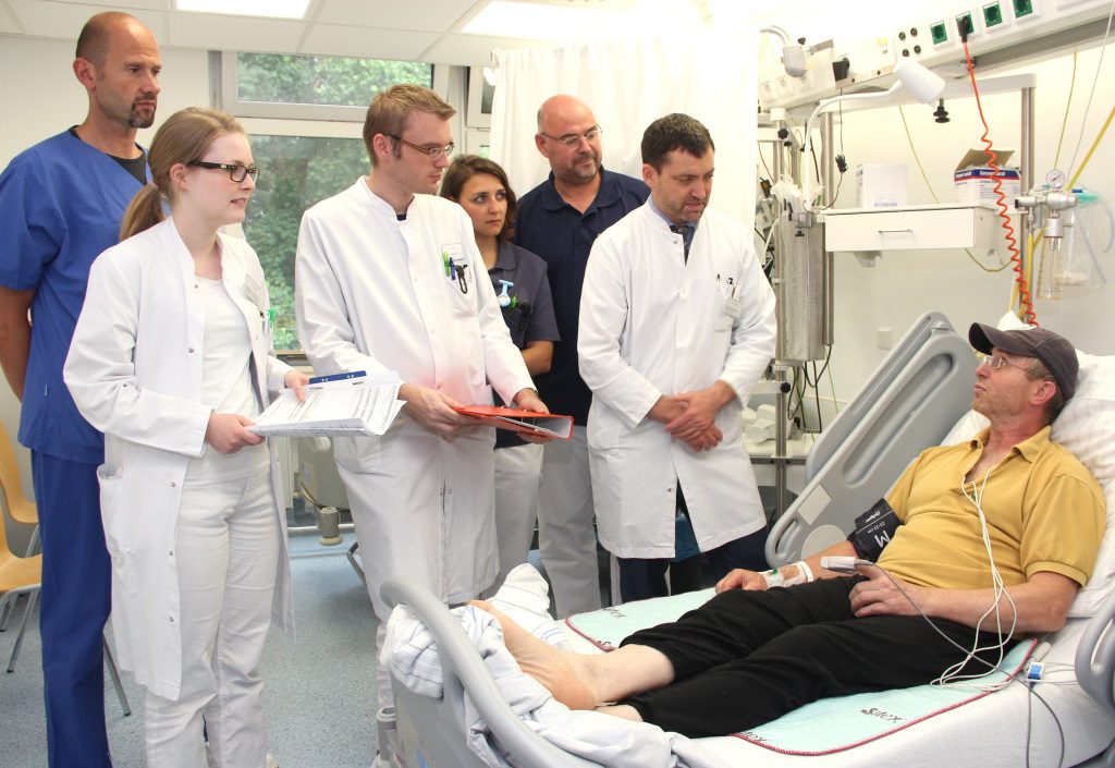 Visite auf der "Stroke-Unit" in der Lukas-Klinik: v.li. David Schott, Pflegerische Leitung Intensivstation, Assistenzärztin Elisa Baron, Oberarzt Hendrick Schapernack, Logopädin Celine Malchow, Ergotherapeut Andreas Knick und Chefarzt Prof. Dr. Marcel Nihé 